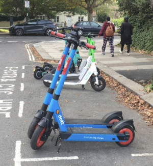 Collection of e-scooters parked in an on-street bay
