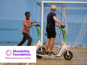 E-scooter training taking place between instructor and learning in an indoor hall